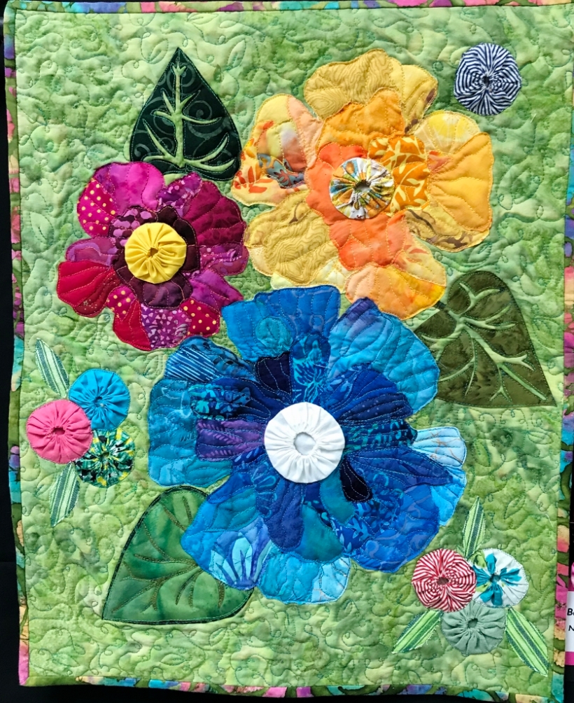 Art quilt depicting large flowers.